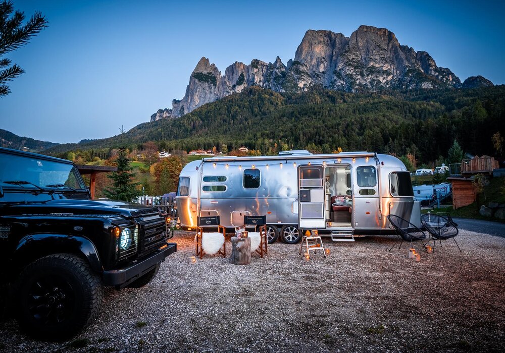 Wohnwagen in der Dämmerung vor Bergpanorama