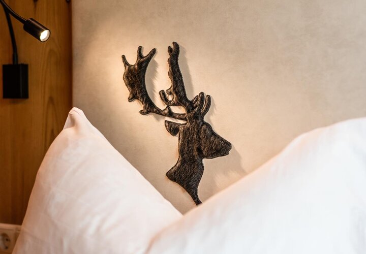 Bett mit Polster und Hirschkopf