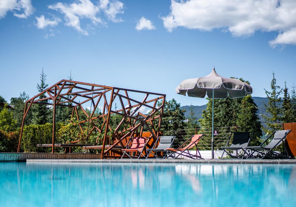 Hollywoodschaukel aus Holz am Pool